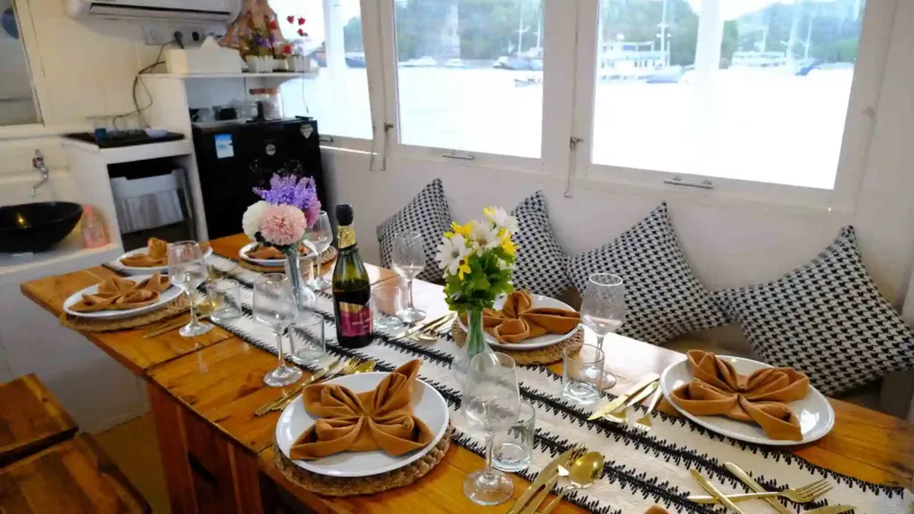 Christmas in Komodo on board: a long dining table set with flowers, napkins and glasses on a phinisi