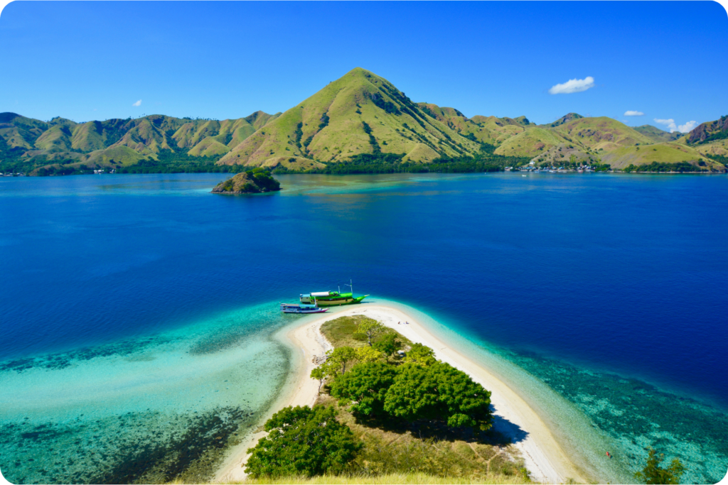 Kelor Island near Labuan Bajo, with a white sandbar and green hills behind