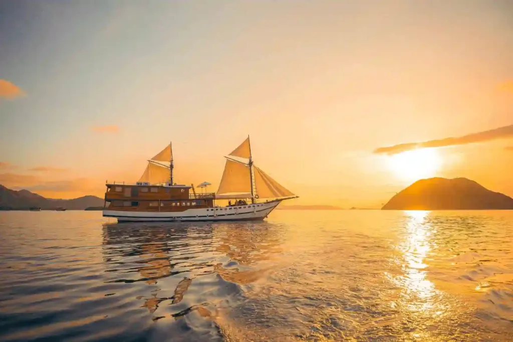 The phinisi Vinca Voyages under sail at sunset